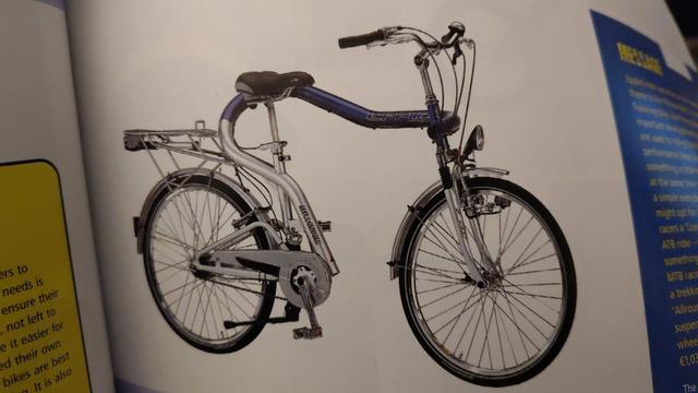 photo of a book. there is a bike in the middle of the shot

the front wheel and handlebar looks normal

the rear wheel and rack and crank looks normal

the frame joining them is difficult to describe but rather than a 2 triangle diamond shape it looks like a question mark or an impossible puzzle made by MC Esher