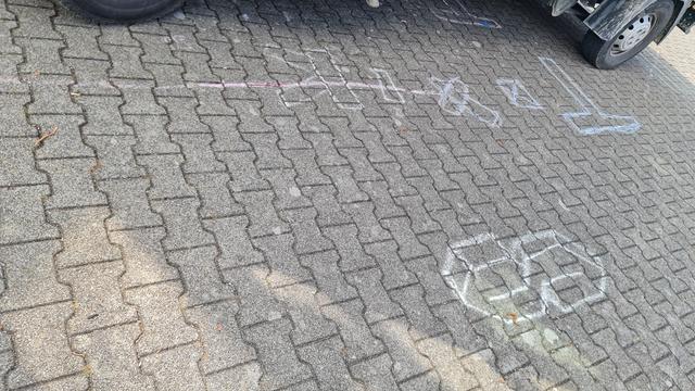 Lauter kinderzeichnungen mit Kreide auf dem gehsteig, eine hat einen Pfeil der auf 'ziel' zeigt, andere die Frage geschrieben 'Was ist dein Ziel?', ein clownsgesicht, ein Polizeiauto