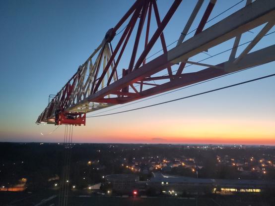 Lever de soleil sur la ville avec une flèche de grue dans le ciel
