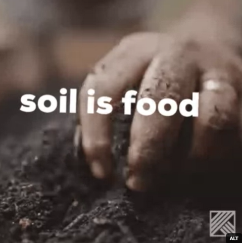 Eine Hand greift in dunkle Erde, mit dem Text 'soil is food' im Vordergrund.