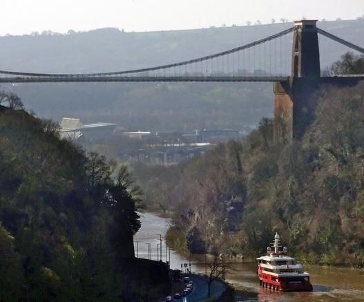 A ship plies the Avon, at high tide, underneath Brunel's suspension bridge.