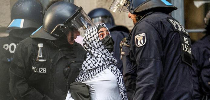 Polizei geht gegen palästinasolidarische Aktivisten in der Berliner Humboldt-Universität vor (23.5.2024)

Das Foto zeigt 5 behelmpte Polizeibeamte, die eine Person, mit Palestinensertuch gesthalten. Einer hält ihr den Mund mit der behandschuhten Hand zu.