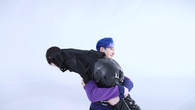 Bang Chan has lifted Seungmin over his shoulder. Chan's arms are firmly locked around Seungmin's thighs, below his butt. Chan is happy.
