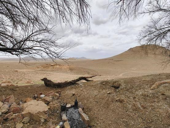 A wide picture of nature from the hillside (there are two things in the picture, one is a teapot and another is "Shamourti" which is used to boil water [faster] on fire, wood or coil fire)