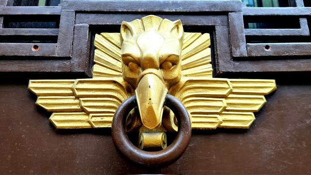A golden Art Deco style eagle-head door handle.