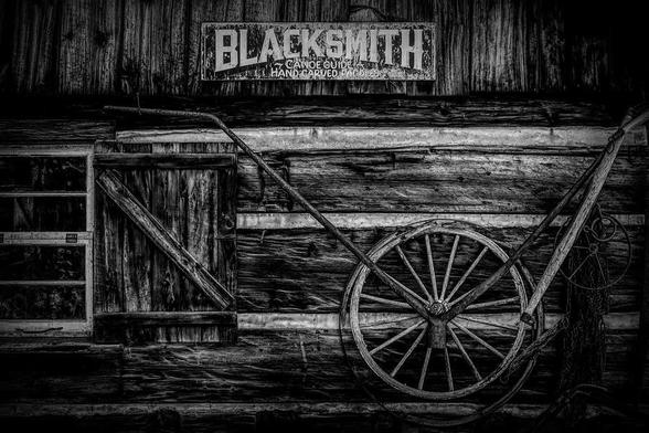 The front facade of a pioneer blacksmith shop is seen in the Muskoka town of Huntsville, Ontario at Heritage Place. Black and white.