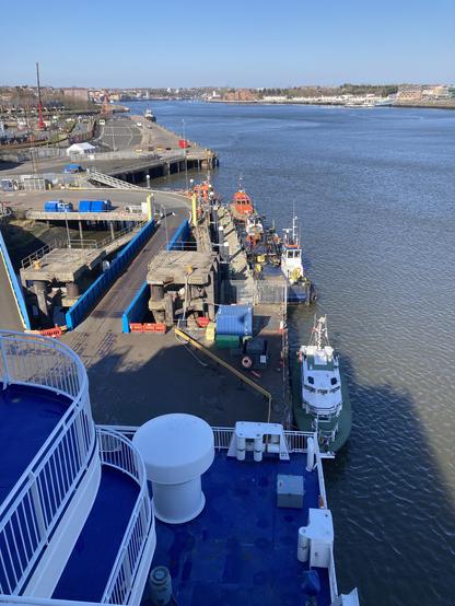 River Tyne from the promenade deck. Clear blue skies above, harbour master’s launch and pilot boats are moored to a jetty below.