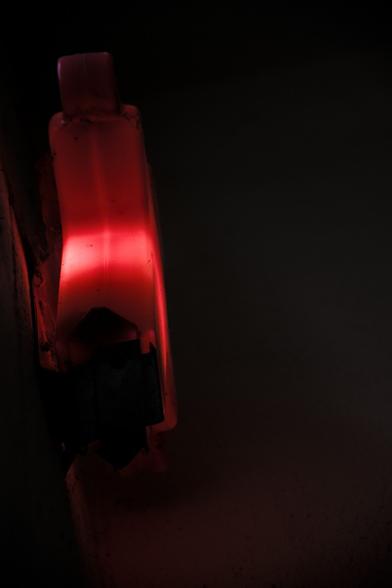 Berlin - Ampelmann de couleur rouge - emblème de Berlin en contre-plongée dans le noir accroché à un mur
