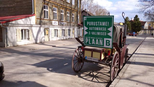 Hobuvanker endise Toome poe ees Jakobi väravas, vaade piki Jakobi tänavat ülikooli peahoone poole, vankril reklaamkirjad Purustame: 1) automaksu, 2) e-valimised -- ja poliitiline tunnuslause "Plaan B"