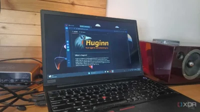 A Lenovo laptop displays the Huginn software interface amidst cables and a Behringer audio mixer on a wooden desk.