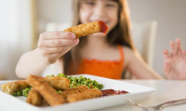 Niña comiendo palitos de pescado. (Getty Images)