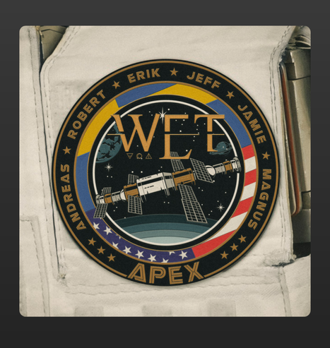 The image shows a mission patch-style design featuring the word "WET" prominently in the center. The patch has a circular shape with a black background and gold lettering. Surrounding the central text are the names "Andreas," "Robert," "Erik," "Jeff," "Jamie," and "Magnus," written along the outer ring. The bottom of the patch features the word "APEX" in bold gold letters.  

The design includes a detailed illustration of a space station orbiting Earth, with solar panels extending outward. The background showcases a star-filled sky with celestial elements such as planets and constellations. The border incorporates red, white, and blue colors, resembling the American flag, along with a European-style yellow and blue section.  

The patch is sewn onto a white astronaut suit, reinforcing the space exploration theme. The aesthetic of the image combines retro space mission insignias with a modern rock or metal album concept, aligning with W.E.T.'s melodic rock style.