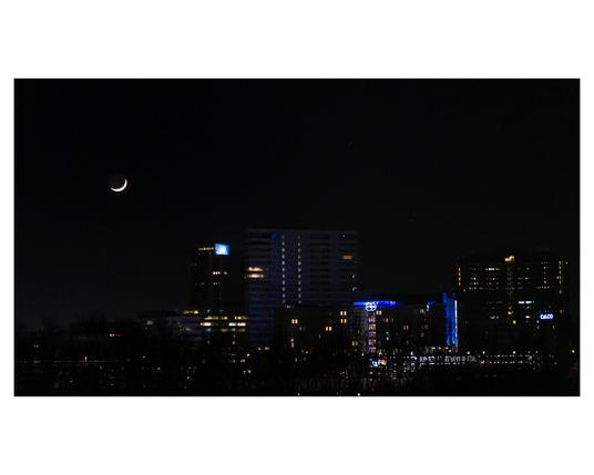 Overview of a cityscape with the moon on it.