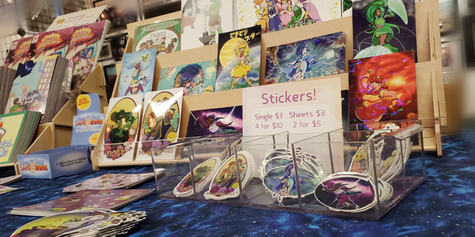 A shelf full of colorful prints & stickers for sale