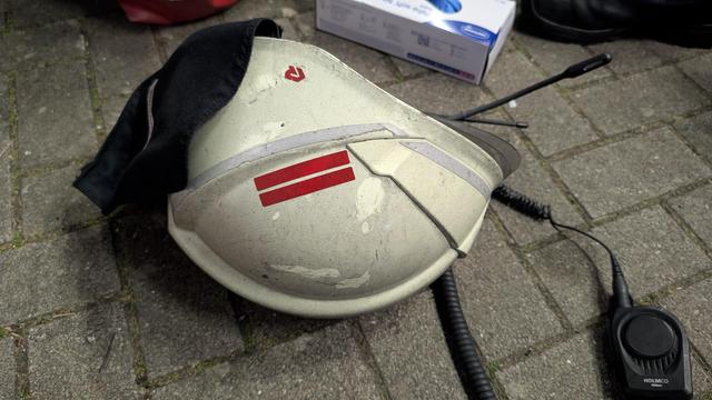 Mit Rauchpartikeln beaufschlagter Feuerwehrhelm liegt auf dem Gehweg.