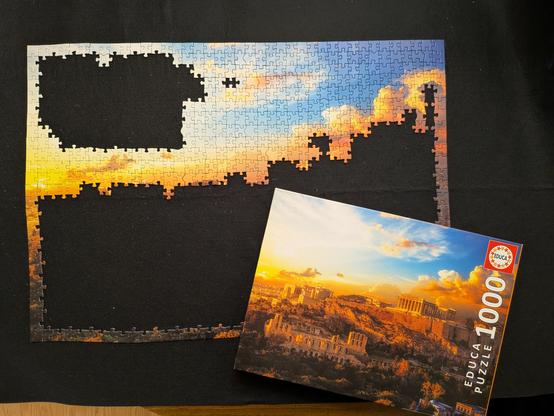 A 1000 piece puzzle approximately 25% complete. The box lid shows the artwork which is Athens at sunset.