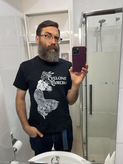 Me wearing the t shirt in a mirror selfie with a raised eyebrow.