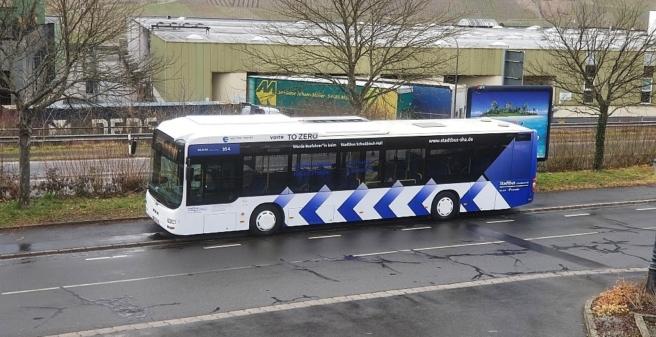 Foto vom umgebauten Bus auf der Straße

Die Grundfarbe ist Weiss, auf Höhe der Räder sind symbolhaft blaue Pfeile abgebildet. Sie erwecken den Eindruck einer Vorwärtsbewegung.