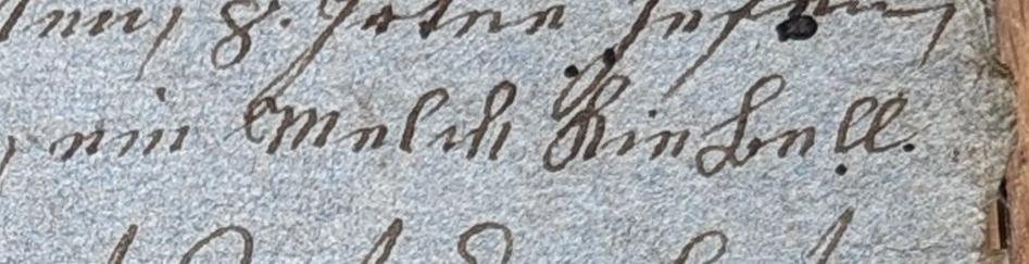 A few lines from the 1821 contract. The only words, that are entirely visible state "ein Melch Kiebell", which was the last thing for her to decipher from the whole contract. It is written with ink on quite raw paper, that looks a bit blue.