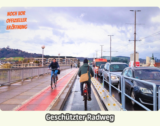 Das Bild zeigt eine Brücke mit einem geschützten Radweg, der noch vor der offiziellen Eröffnung genutzt wird. Auf der linken Seite des Bildes fahren zwei Radfahrer auf einem roten Radweg, der von einer Metallbrüstung abgegrenzt ist. Der Radweg ist nass, was auf kürzliche Regenfälle hinweist.