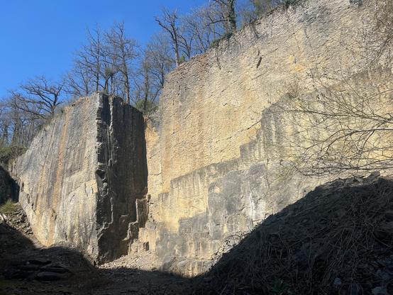 A similar view of the sunlit wall as in the first picture, but from another angle.
In the middle of the wall there's a 8 by 8m cutout where a large beam-shaped part of the rock has been quarried. The sides of the cutout are lined with vertical cracks that can be used to climb.