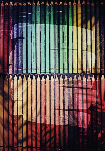 Une boîte de Crayons pastels multicolores. Le tour de l'image est sombre tandis qu'une gribouille éclaire le centre.