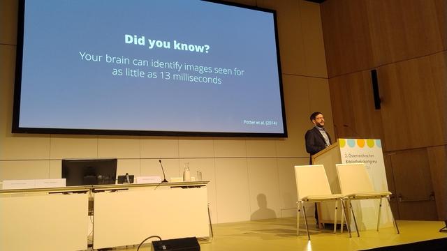 Peter Kraker giving a presentation at the 2nd Austrian Library Congress. Behind him is a large presentation slide reading: "Did you know? Your brain can identify images seen for as little as 13 milliseconds."