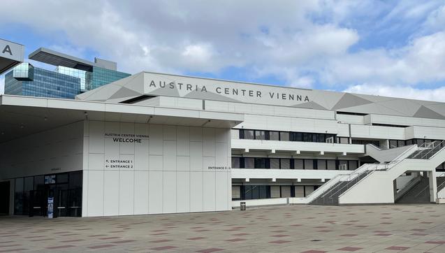 Exterior view of the Austria Center Vienna, the modern venue hosting the 2nd Austrian Library Congress, under a partly cloudy sky.