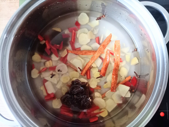 Ingwer Chili Zimtstangen Nelken Tamarindenmark + Wasser in einem Topf