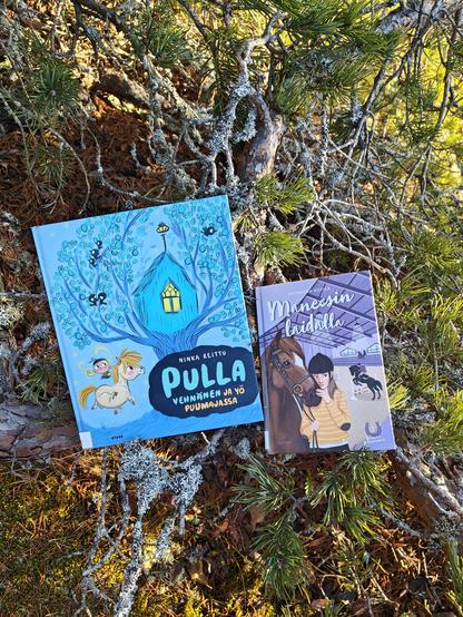 Kuvassa tekstissä esitellyt heppakirjat kuvattuna havupuun oksan päällä.