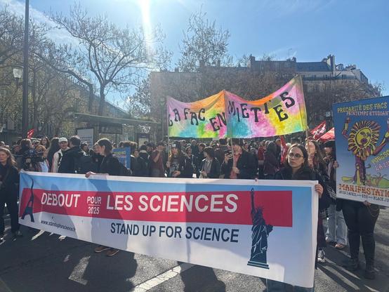 Marche pour les sciences du jeudi 3 avril 2025 au matin : foule sous le soleil, banderoles "Debout pour les sciences 2025", "La fac en miettes", "Printemps des facs"