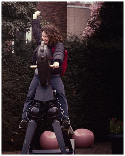 A person riding a large toy horse