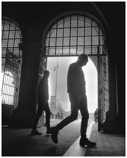 Persons walking under an arch