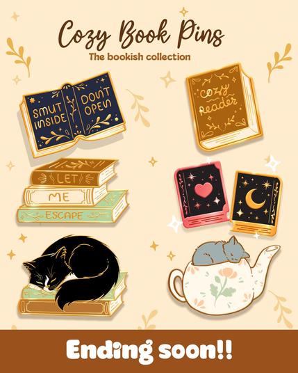 An image with the depiction of 7 enamel pins celebrating a love of cozy books (and smutty books) and every readers favourite feline friends. 
With the text "Cozy Book Pins. The bookish collection." and at the bottom "Ending soon!"