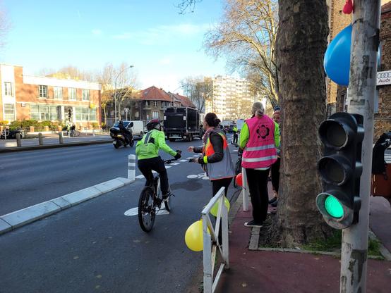 Personne en train de donner un flyer (du baromètre vélo) à un cycliste le long d'une piste cyclable