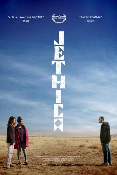 Un póster de la película "Jethica", una comedia oscura. El título de la película está escrito verticalmente en el centro del póster, sobre un fondo de un cielo azul claro. En la parte inferior, dos mujeres jóvenes están de pie juntas en un campo desértico, mientras que un hombre está de pie a cierta distancia de ellas, mirando hacia ellas. En la parte superior del póster, hay citas de reseñas que describen la película como "un deleite verdaderamente macabro" y "oscuramente cómica".  También se indica que la película fue seleccionada en el Festival de Cine SXSW 2022.