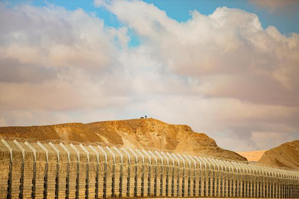 Photograph of a fence demarcating the border between two countries. By Mussi Katz, under a free Flickr License: https://www.flickr.com/photos/mussikatz/50758919936/ .