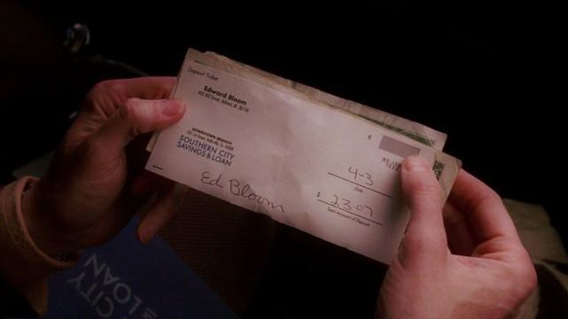A man’s hands holding a bank deposit slip dated April 3.
