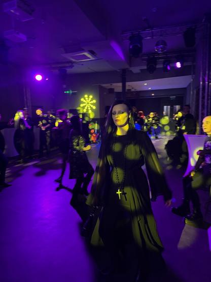 Young woman in black dancing at a goth club in London.