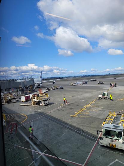 A view from the mezzanine peering out into the vast expanse of grey concrete and steel—The modern airport runway
