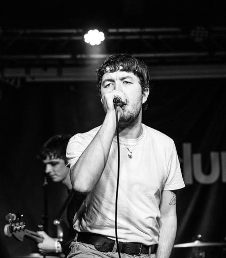 Black and white photo of a rock singer singing into a microphone