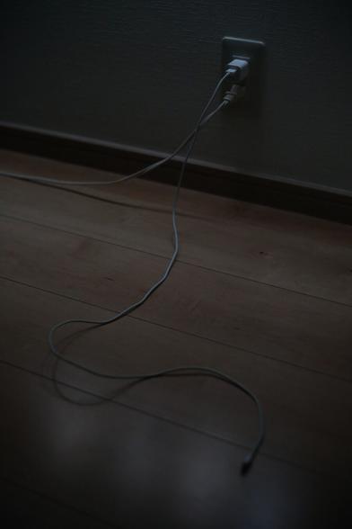 The iPhone charging cable snakes across the floor.