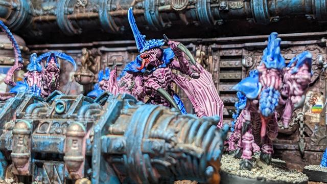 A group of Tyranids aliens painted in blue and purple. Here you can see the focus on the alien leader. The photo is taken from below.