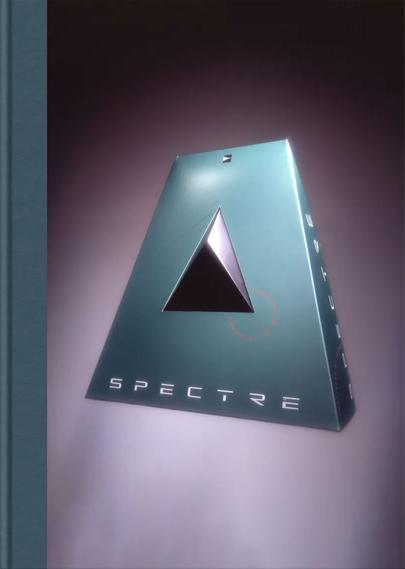 Minimalist book cover titled "SPECTRE" featuring a futuristic, teal pyramid-shaped video game box design with a black triangular cutout in the center. The stylized text and sleek aesthetic highlight the work of Hock Wah Yeo, known for his bold and experimental packaging designs in the 1990s. The lighting emphasizes the geometric contours of the box, set against a gradient background for a dramatic effect.

 Gone are the days when publishers were simultaneously battling for shelf space and consumer’s attention with brightly coloured boxes, additional paper paraphernalia and gigantic marketing posters showcasing the blockbuster hits of the eighties and nineties. Every game on the shelves was designed to shout at passers-by, but perhaps the loudest voices came from the unusually shaped, yet ingenious boxes created by Hock Wah Yeo.

Videogame Box Works is a tribute to the extraordinary craftsmanship behind Hock Wah Yeo's meticulously engineered game boxes and a redesigned and expanded hardback edition of Colpa Press’s ultra-short run 2021 publication. This new tome delves into why Yeo’s boxes were prized artefacts of collectors around the world, but the bane of shelf stockists for over a decade and chronicles his remarkable contributions to the gaming industry between the years of 1988 and 1997, showcasing his innovative designs that added a veil of wonder to games before you even removed the packaging. Each inventive box featured within the pages has brand new commentary from Ye