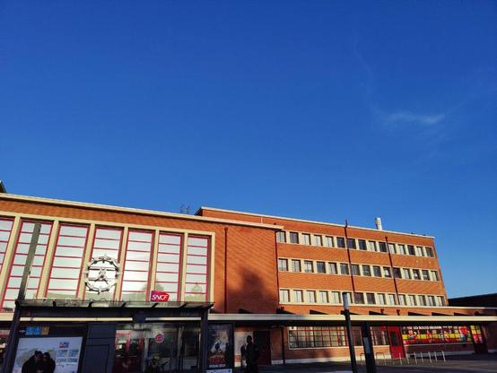 Photo de la gare de Douai sous un grand ciel bleu.