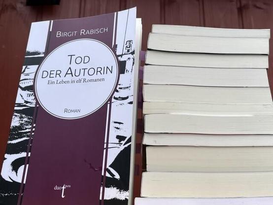 Das Buch "Tod der Autorin" neben einem Bücherstapel