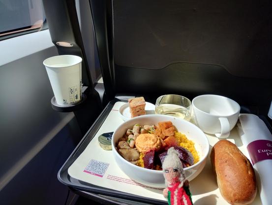 Puppet enjoys couscous with hummus and stuff, along with a bread roll and a glass of white.