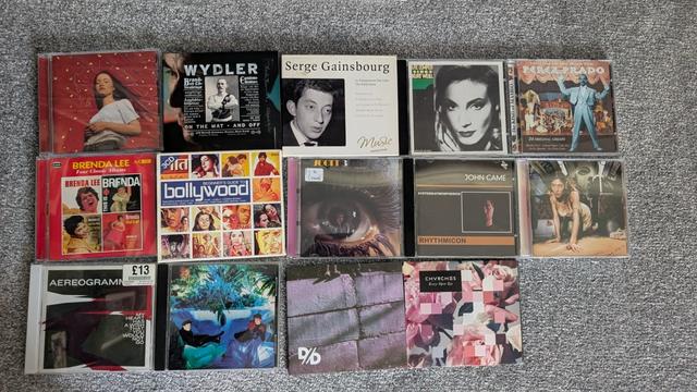 A photo of CDs on a floor with these being by the following :
Sigrid, Thomas Wydler, Serge Gsinsbourg, Ute Lemprr, Perez Prado
Brenda Lee, The Beginners Guide to Bollywood, Scott Walker, John Came, Caroline Polachek,
Aerogramme, Associates, Divide Dissolve, Chvrches