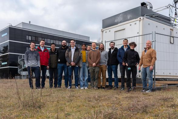 In the picture are 13 people who are involved with the current experiments at MPL. They are standing in front of the ground station.