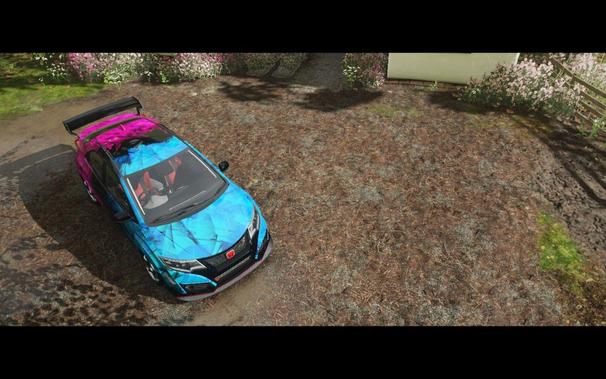 A vibrant blue and pink race car on a muddy track, first person perspective from inside the vehicle.